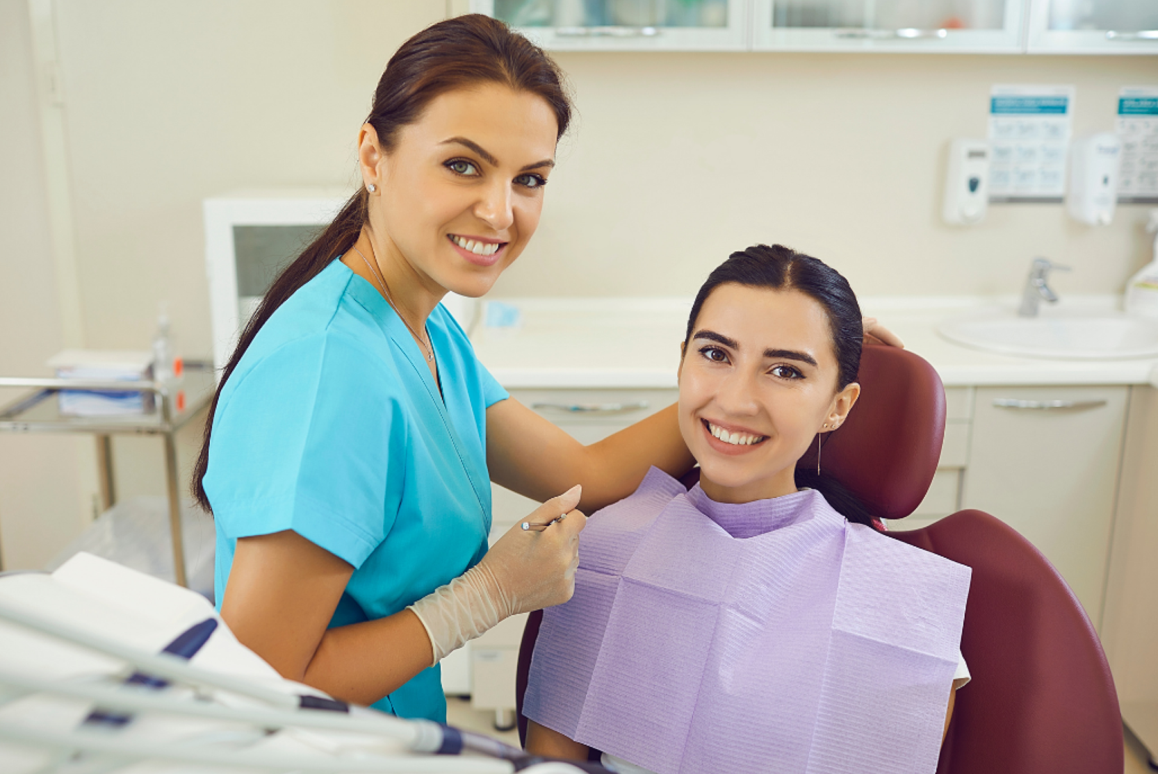 Dental nurse with a smiling patient in the chair