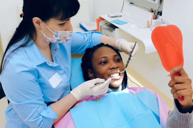 Patient checking her smile in a hand mirror